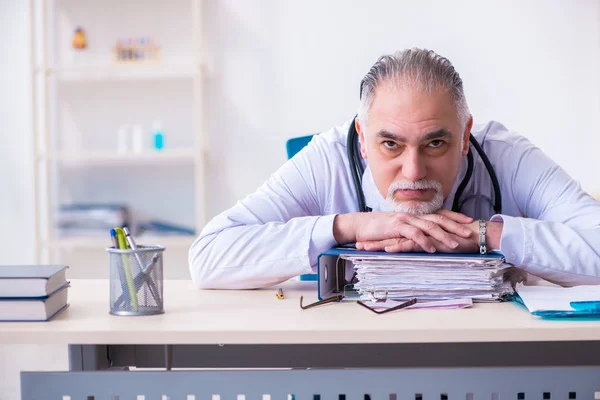 Klinikte çalışan yaşlı erkek doktor. — Stok fotoğraf