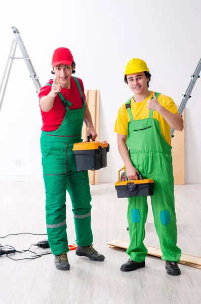 Dois trabalhadores empreiteiros que trabalham dentro de casa — Fotografia de Stock