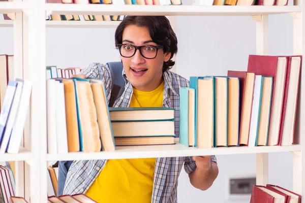 Mannelijke student bereidt examens in de bibliotheek voor — Stockfoto