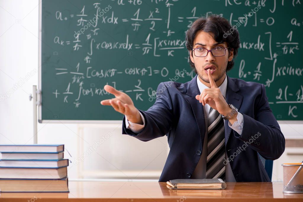 Young male math teacher in classroom