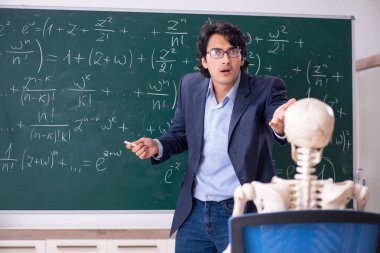 Genç erkek matematik öğretmen ve öğrenci iskelet