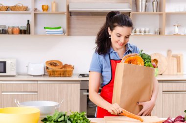 Mutfakta sebzeli genç bir kadın.