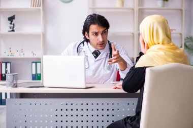 Kadın Arap hasta, erkek doktoru ziyaret ediyor.