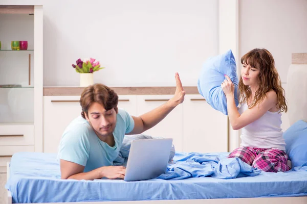 Pareja joven con portátil en el dormitorio — Foto de Stock