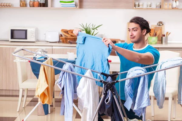 Jovem marido fazendo roupas de engomar em casa — Fotografia de Stock