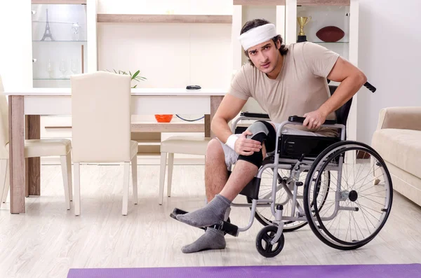 Injured young man doing exercises at home — Stock Photo, Image