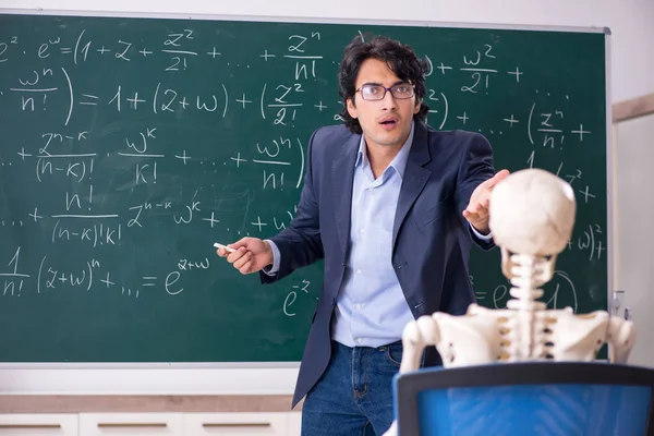Joven profesor de matemáticas masculino y esqueleto de estudiante —  Fotos de Stock