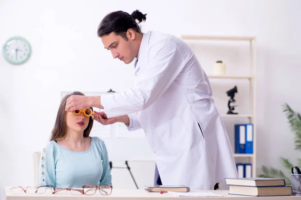 Giovane donna in visita medico oculista maschile — Foto Stock