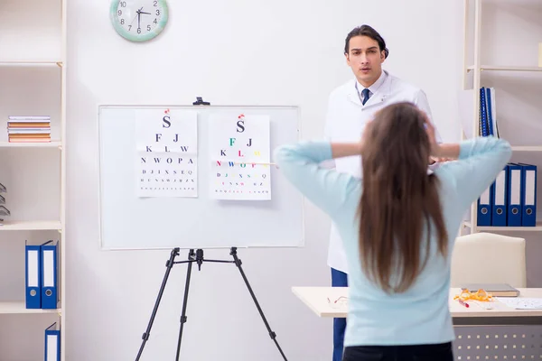 Jeune femme visitant médecin oculiste masculin — Photo