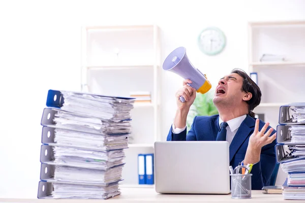 Giovane dipendente maschio infelice con il lavoro eccessivo — Foto Stock