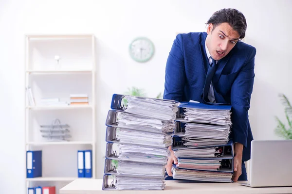 Jonge mannelijke werknemer ongelukkig met overmatig werk — Stockfoto