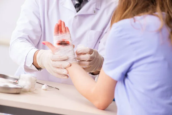 Mão ferida mulher visitante médico traumatologista — Fotografia de Stock