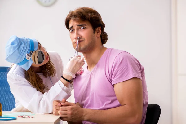 Ung vacker man besöker unga kvinnliga läkare otolaryngologist — Stockfoto