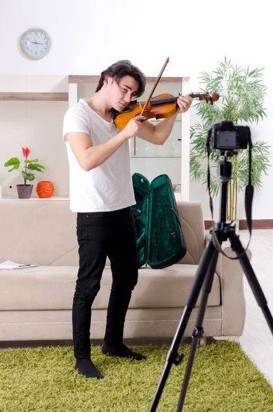 Mladý muž blogger hraje doma na housle — Stock fotografie