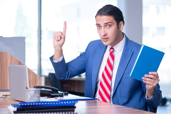 Jovem empresário bonito sentado no escritório — Fotografia de Stock