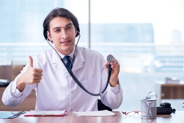 Joven médico guapo que trabaja en la clínica — Foto de Stock