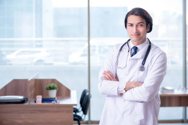 Joven médico guapo que trabaja en la clínica —  Fotos de Stock