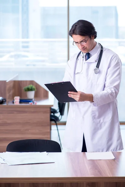 Jonge knappe dokter werkt in de kliniek — Stockfoto