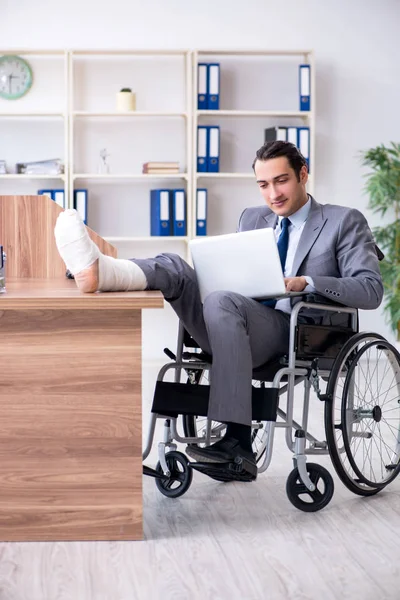 Mężczyzna pracownik na wózku inwalidzkim w biurze — Zdjęcie stockowe