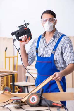 Genç erkek marangoz içeride çalışıyor.