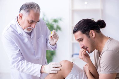 Erkek hasta aşı aşısı için doktoru ziyaret ediyor.