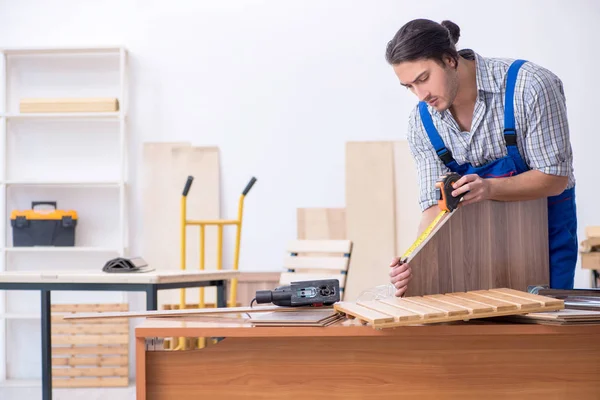 Joven carpintero masculino trabajando en interiores — Foto de Stock