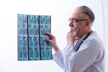 Klinikte çalışan yaşlı erkek doktor.