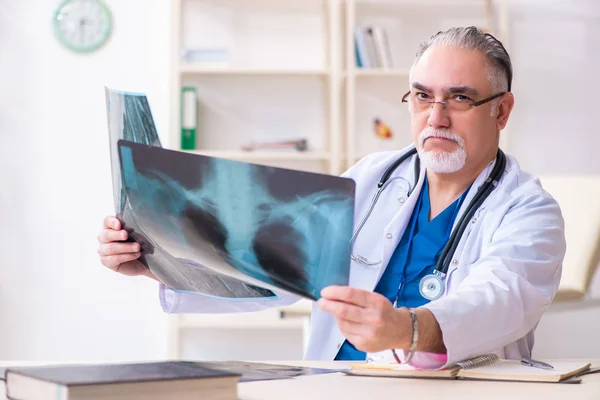 Klinikte çalışan yaşlı erkek doktor. — Stok fotoğraf