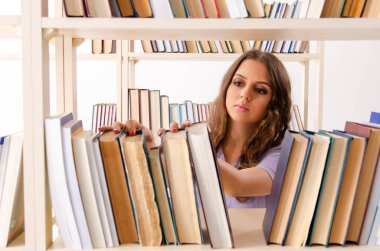 Genç kız öğrenci kütüphanede sınava hazırlanıyor.