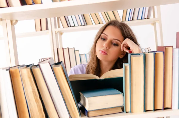 Jovem estudante se preparando para exames na biblioteca — Fotografia de Stock