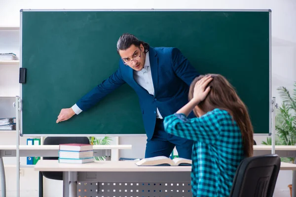 Jovem e bonita professora e estudante em sala de aula — Fotografia de Stock