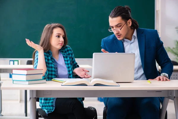 Jonge knappe leraar en vrouwelijke student in de klas — Stockfoto