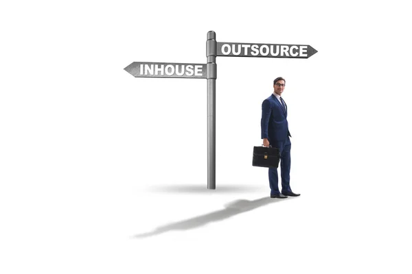 Businessman at crossroads deciding between outsourcing and inhou — Stock Photo, Image