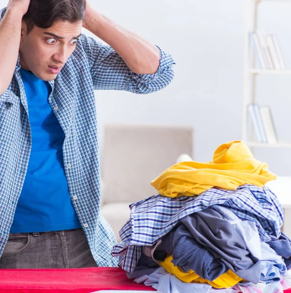 Joven marido haciendo planchado de ropa en casa — Foto de Stock