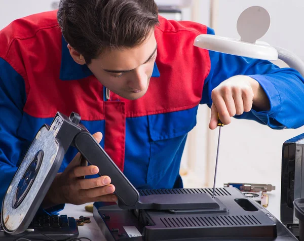 Professional repairman repairing computer in workshop