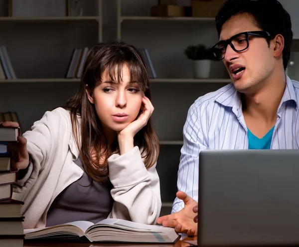 Dos estudiantes que estudian tarde preparándose para los exámenes — Foto de Stock