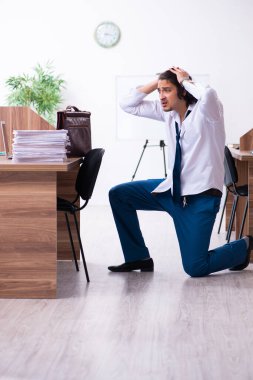 Genç bir erkek işçi aşırı işten memnun değil.