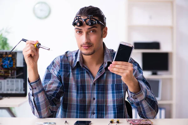Genç yakışıklı teknisyen cep telefonu tamir