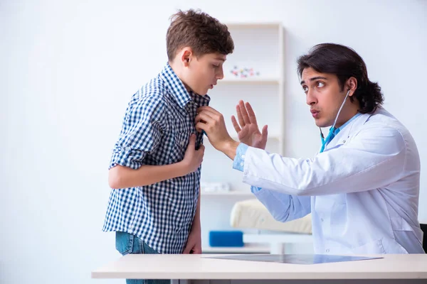 Mężczyzna lekarz bada chłopca przez stetoskop — Zdjęcie stockowe