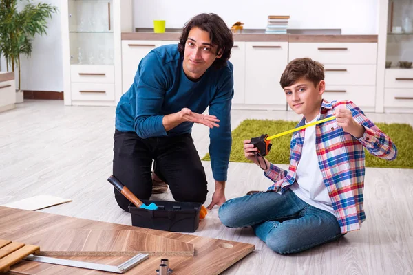 Jovem carpinteiro ensinando seu filho — Fotografia de Stock