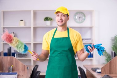 Genç müteahhit ofisi temizliyor.