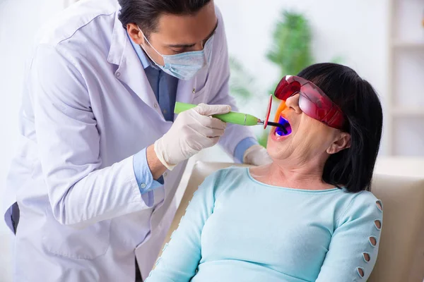Vieja mujer visitando joven médico dentista — Foto de Stock