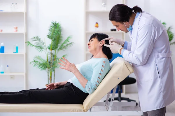 Old woman visiting young doctor laryngologist — Stock Photo, Image