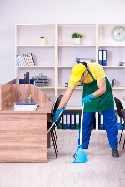 Jovem empreiteiro limpando o escritório — Fotografia de Stock