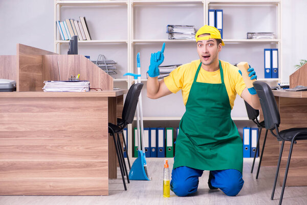 Молодой мужчина-подрядчик убирает офис