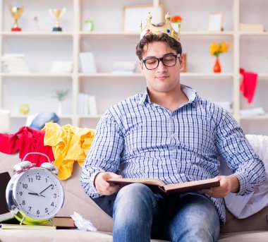 Genç adam dağınık bir odada çalışıyor.