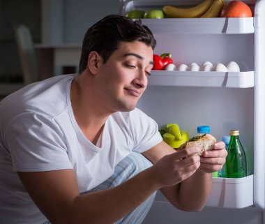 Buzdolabındaki adam gece yemek yiyor.