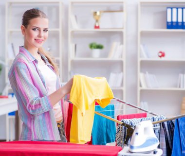 Genç ev hanımı evde çamaşır yıkıyor.