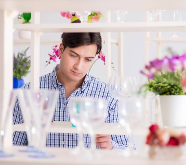 Genç yakışıklı dükkândan alışveriş yapıyor.