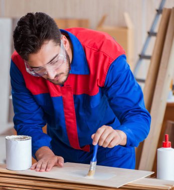 Yooung marangoz boyayla uğraşıyor.